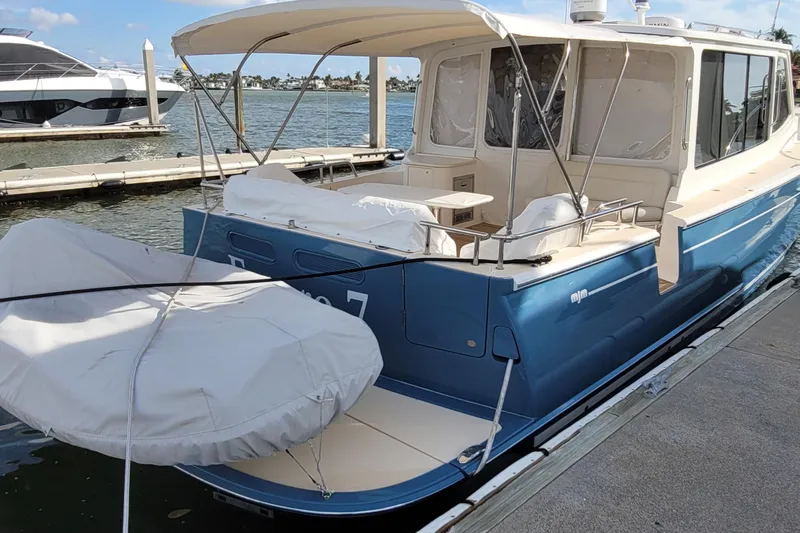 Slide: The Image of 2018 MJM 50z yacht docked at marina, featuring blue hull and covered deck area. - 6