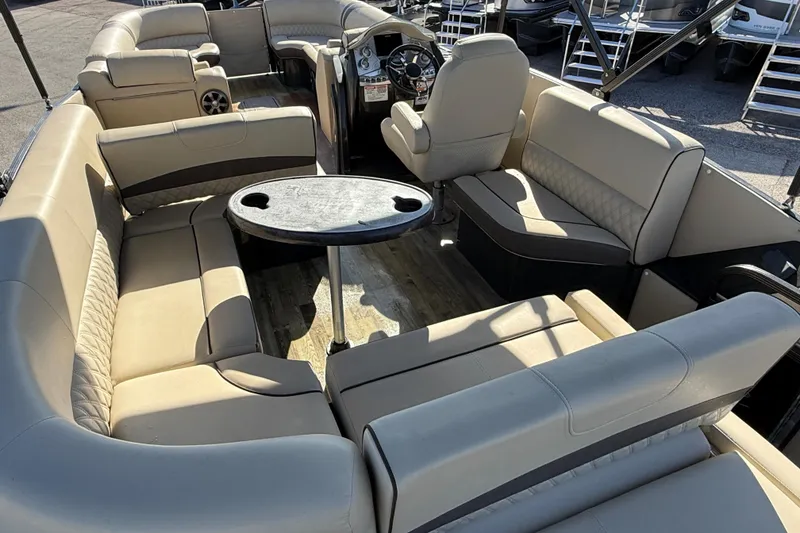 Slide: The Image of 2019 Crest Caribbean 250 SLS pontoon boat interior with beige seating and table. - 10