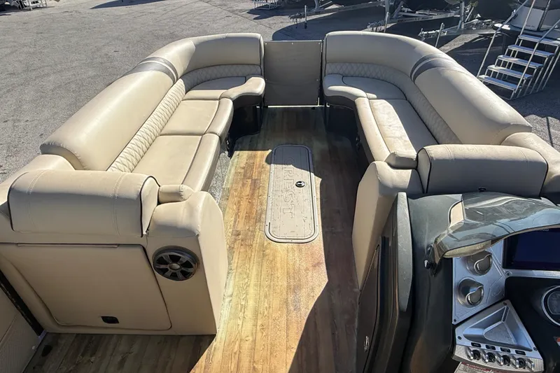 Slide: The Image of 2019 Crest Caribbean 250 SLS pontoon boat interior with beige seating and wood flooring. - 12