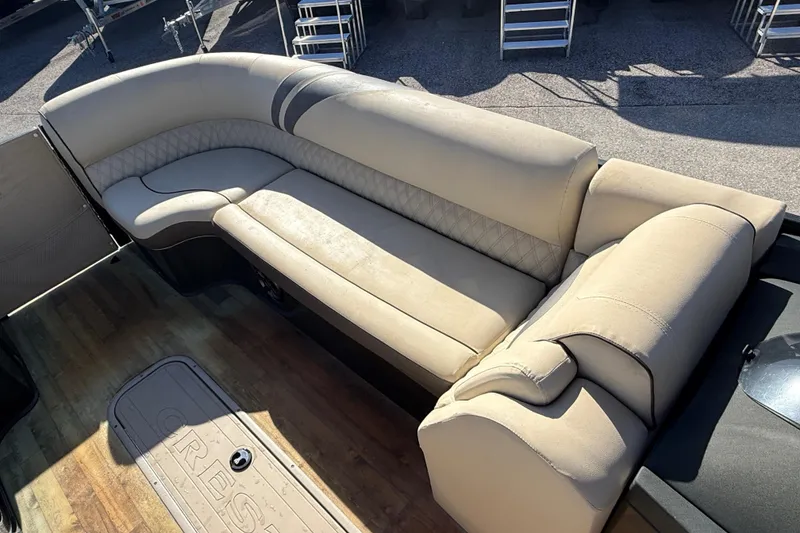 Slide: The Image of 2019 Crest Caribbean 250 SLS boat interior with beige seating and wood flooring. - 14