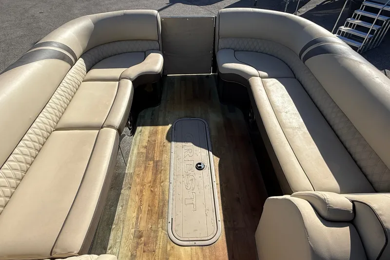 Slide: The Image of 2019 Crest Caribbean 250 SLS boat interior with beige seating and wood flooring. - 16
