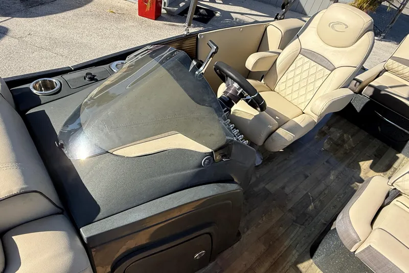 Slide: The Image of 2019 Crest Caribbean 250 SLS boat interior with beige seating and steering console. - 18