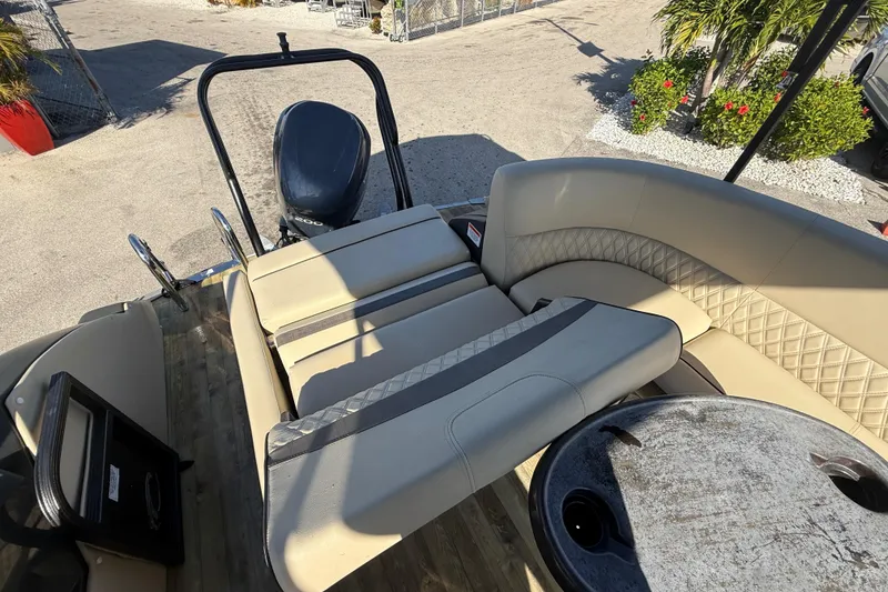 Slide: The Image of 2019 Crest Caribbean 250 SLS boat interior with seating and motor, docked outdoors. - 23