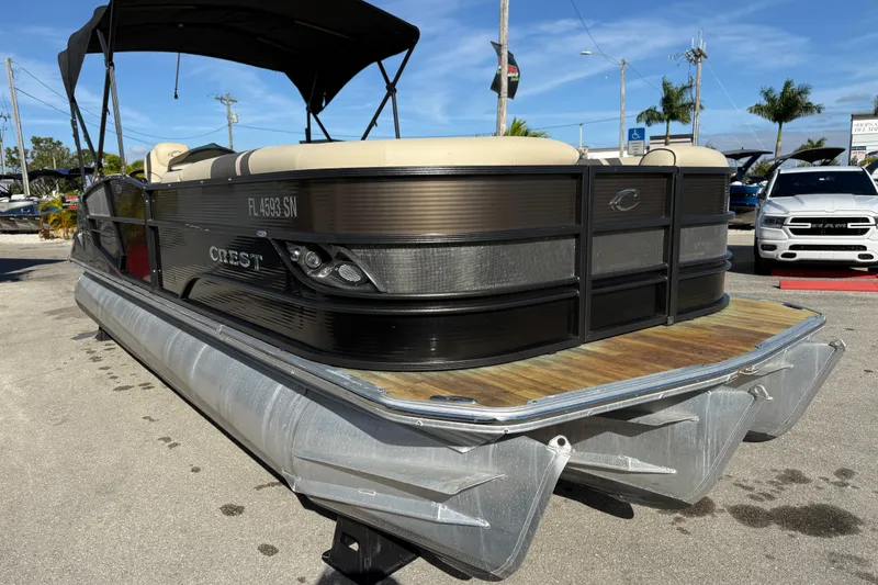 Slide: The Image of 2019 Crest Caribbean 250 SLS pontoon boat with canopy, parked on pavement. - 5