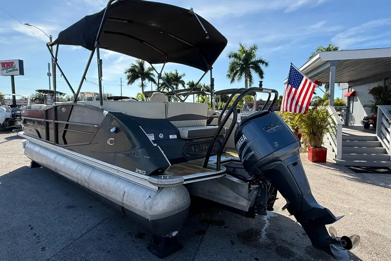 Slide: The Image of 2019 Crest Caribbean 250 SLS pontoon boat with Yamaha outboard motor, docked under sunny skies. - 8