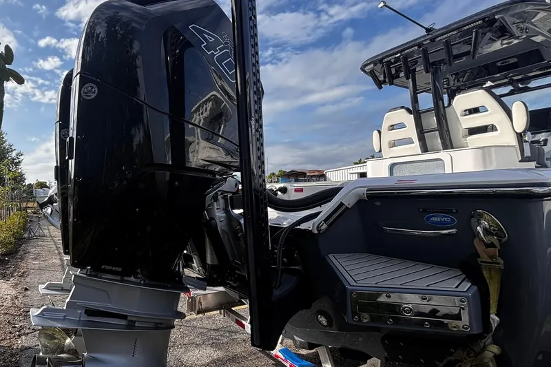 Slide: The Image of 2026 Tidewater 3100 Carolina Bay boat with powerful outboard motor, docked under blue sky. - 11