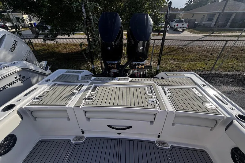 Slide: The Image of 2026 Tidewater 3100 Carolina Bay boat interior with three cushioned seats and dual engines. - 17