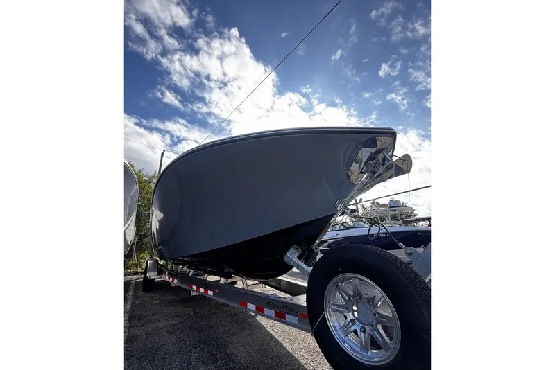 Slide: The Image of 2026 Tidewater 3100 Carolina Bay boat on trailer under a cloudy sky. - 4