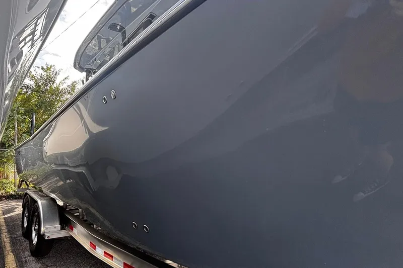 Slide: The Image of 2026 Tidewater 3100 Carolina Bay boat with dual outboard engines on a trailer. - 6