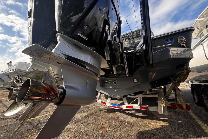 Slide: The Image of 2026 Tidewater 3100 Carolina Bay boat with dual outboard motors and ladder, parked on a trailer. - 8