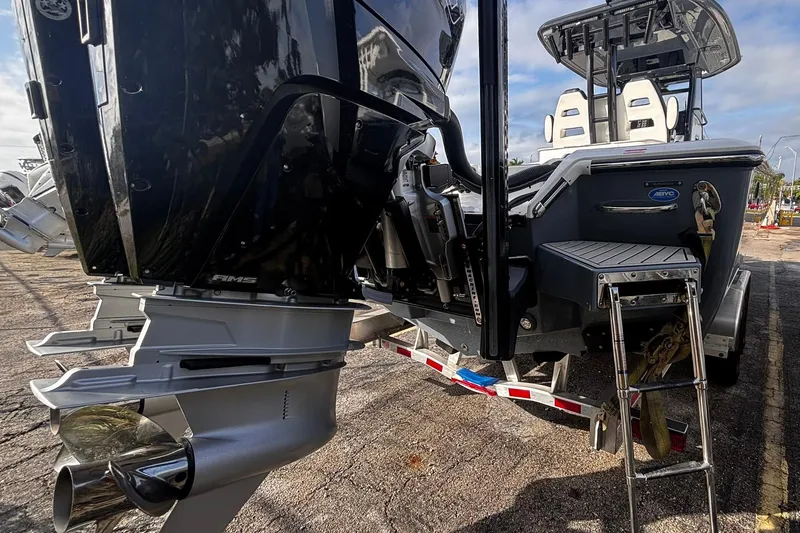 Slide: The Image of Twin outboard engines on a 2026 Tidewater 3100 Carolina Bay boat, parked outdoors. - 9