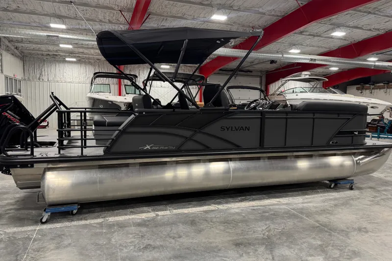 Slide: The Image of 2026 Sylvan X 5 pontoon boat in a showroom with red beams and other boats. - 4