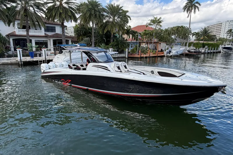 Slide: The Image of 2019 MTI V42 boat cruising near waterfront homes with palm trees. - 6
