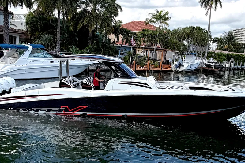 Slide: The Image of 2019 MTI V42 boat cruising on a scenic waterway with palm trees in the background. - 7