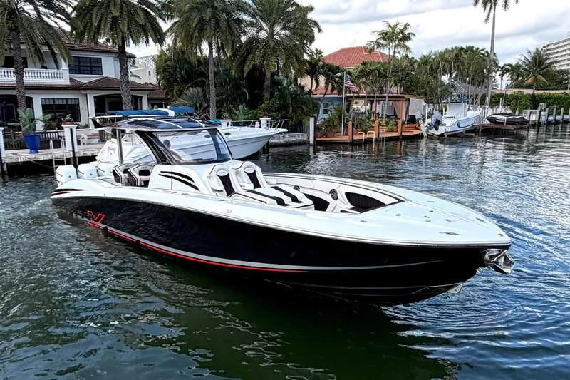 Slide: The Image of 2019 MTI V42 boat docked in a scenic waterfront setting with palm trees. - 8