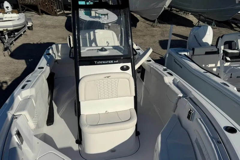 Slide: The Image of 2026 Tidewater 232 LXF boat interior with seating and console, docked outdoors. - 20