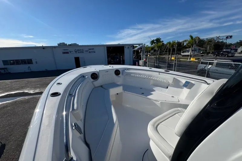 Slide: The Image of 2026 Tidewater 232 LXF boat interior with seating, docked under clear blue sky. - 22