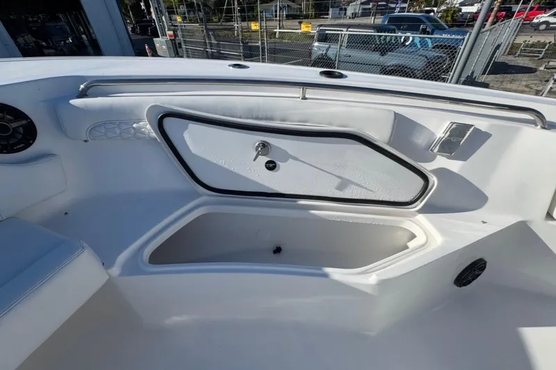 Slide: The Image of 2026 Tidewater 232 LXF boat interior with storage compartment and speaker. - 23