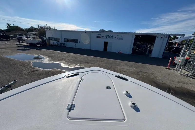 Slide: The Image of 2026 Tidewater 232 LXF boat at a marina with a service building. - 25