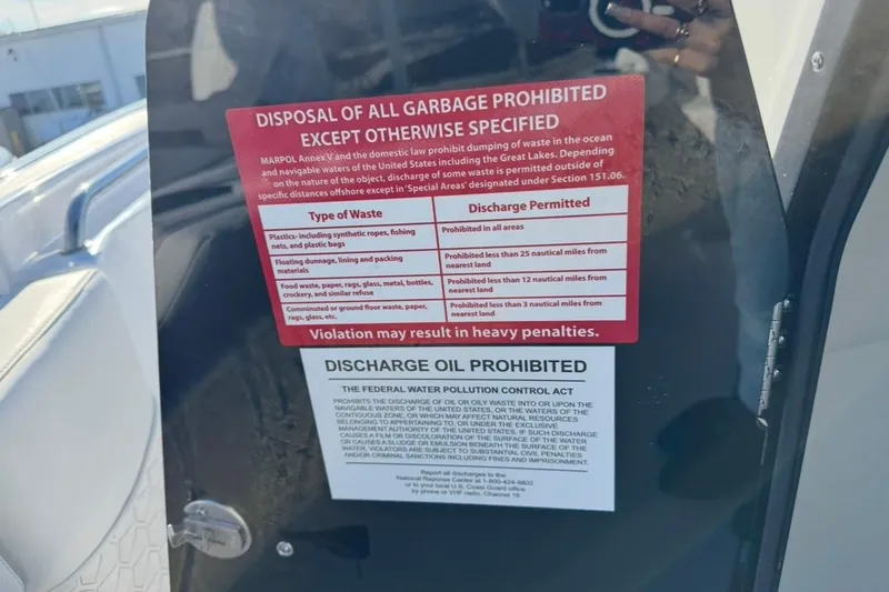 Slide: The Image of Sign on 2026 Tidewater 232 LXF boat detailing waste disposal regulations and penalties. - 28