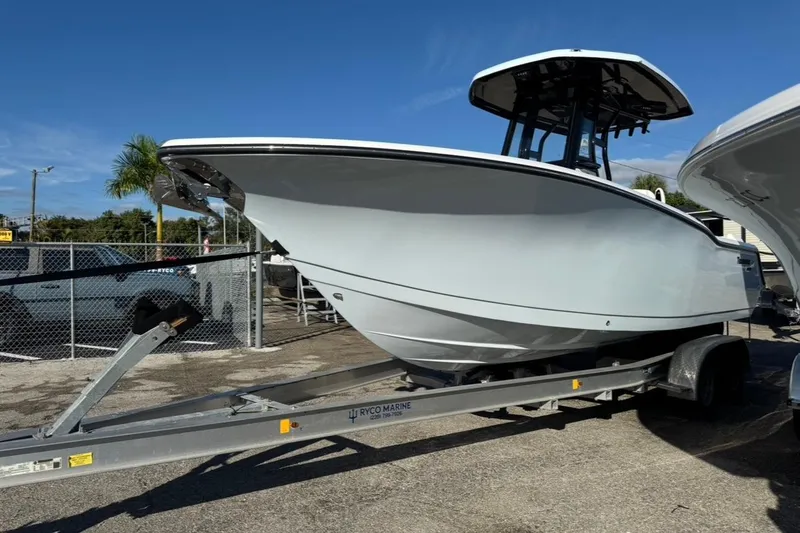 Slide: The Image of 2026 Tidewater 232 LXF boat on trailer, parked outdoors under clear blue sky. - 3