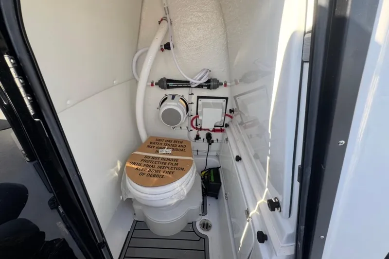 Slide: The Image of 2026 Tidewater 232 LXF boat interior with compact marine toilet and storage. - 30