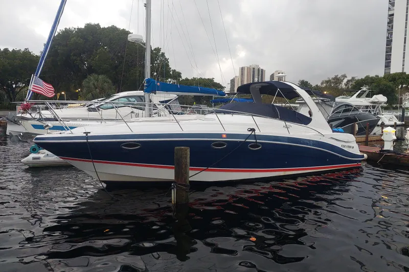 The Image of 2005 Four Winns 348 Vista boat docked in marina, featuring sleek design and American flag. - 0