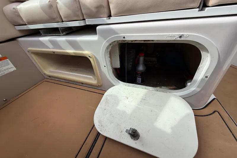 Slide: The Image of 2005 Four Winns 348 Vista boat storage compartment with open hatch and visible items inside. - 100