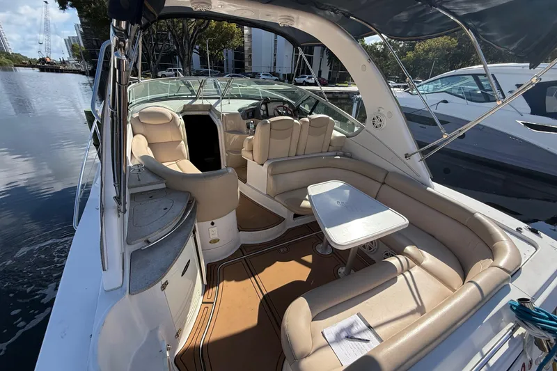 Slide: The Image of 2005 Four Winns 348 Vista boat interior with seating and table, docked by the water. - 19