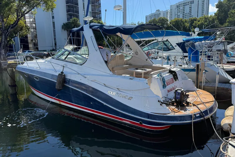 Slide: The Image of 2005 Four Winns 348 Vista boat docked at marina, surrounded by lush greenery. - 2