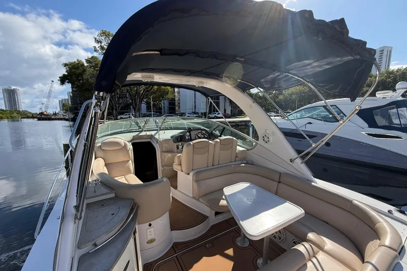 Slide: The Image of 2005 Four Winns 348 Vista boat interior with seating and table, docked by the water. - 20