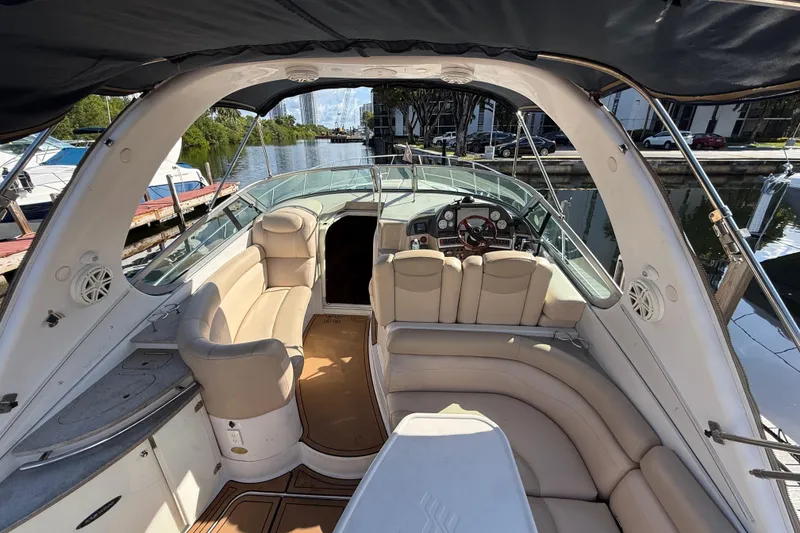 Slide: The Image of 2005 Four Winns 348 Vista boat interior with beige seating and steering area. - 23