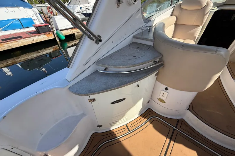 Slide: The Image of 2005 Four Winns 348 Vista boat interior with seating and counter space at a marina. - 24