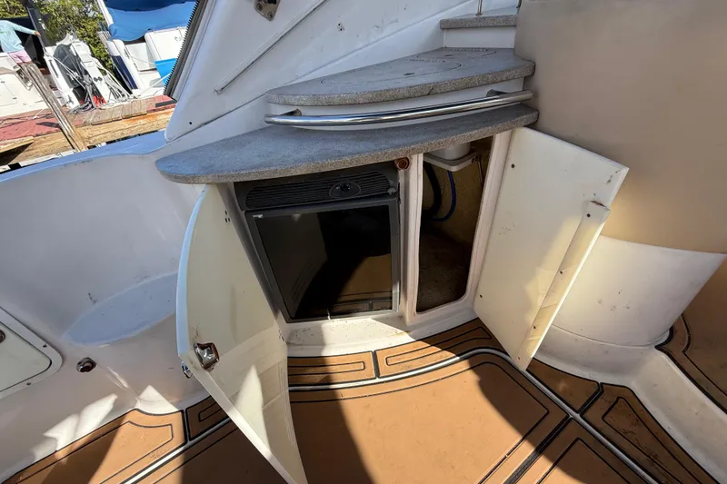 Slide: The Image of 2005 Four Winns 348 Vista boat interior with open cabinet and mini fridge. - 25
