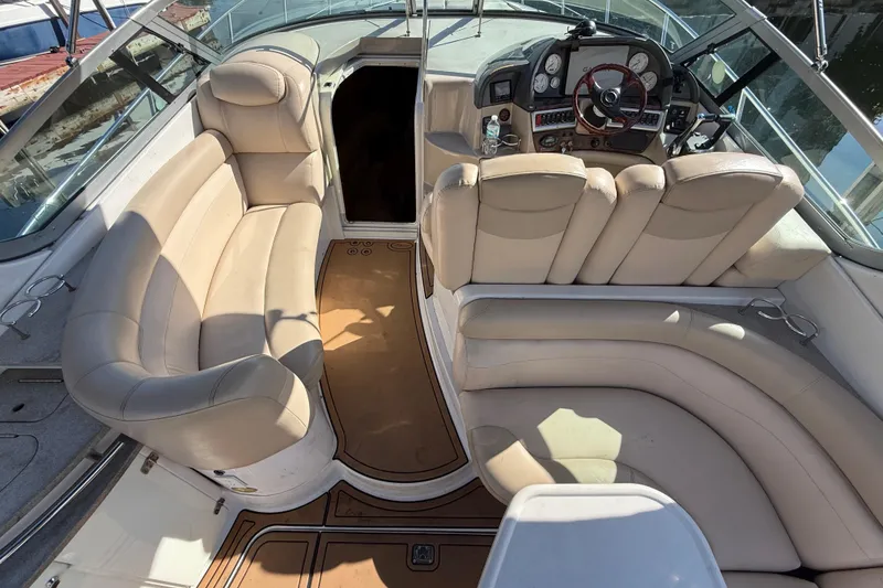 Slide: The Image of 2005 Four Winns 348 Vista boat interior with beige seating and steering console. - 28