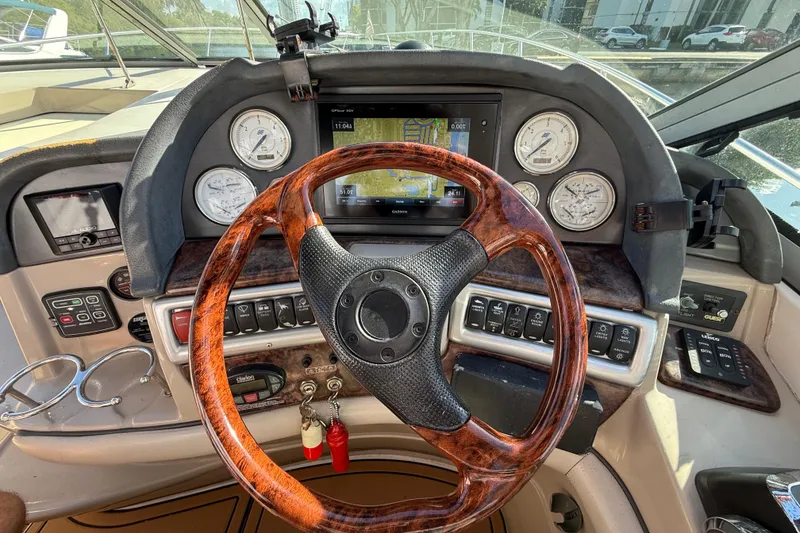 Slide: The Image of 2005 Four Winns 348 Vista boat dashboard with wooden steering wheel and navigation instruments. - 33