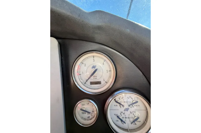 Slide: The Image of Dashboard gauges of a 2005 Four Winns 348 Vista boat, showing RPM, trim, and fuel levels. - 38