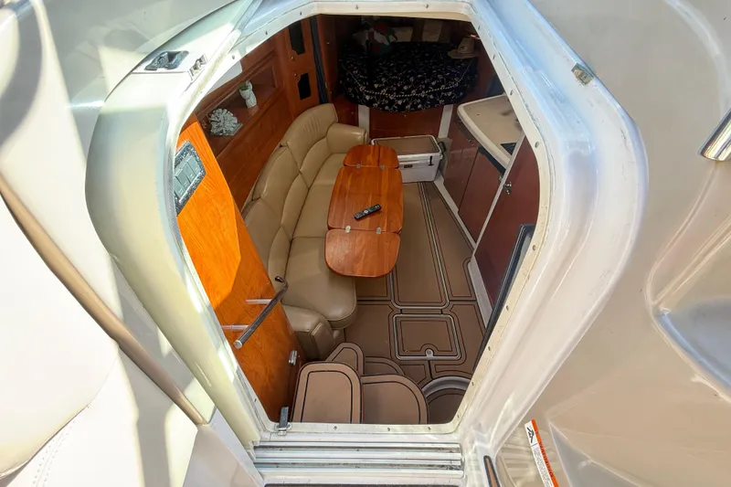 Slide: The Image of Interior view of 2005 Four Winns 348 Vista boat, featuring cozy seating and wooden table. - 45