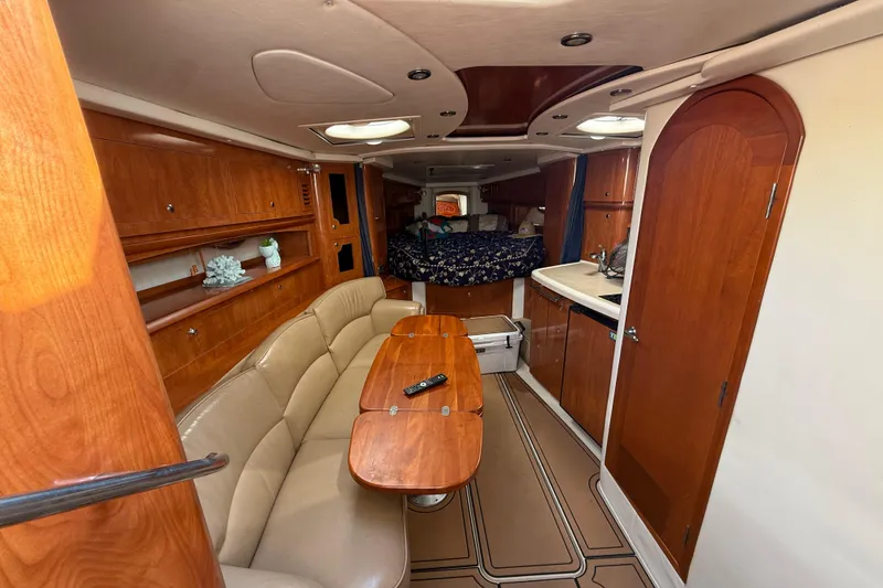 Slide: The Image of 2005 Four Winns 348 Vista cabin interior with wood finish, seating, and kitchenette. - 48