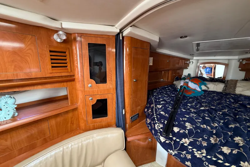 Slide: The Image of Luxurious 2005 Four Winns 348 Vista cabin interior with wood finish and cozy bedding. - 52