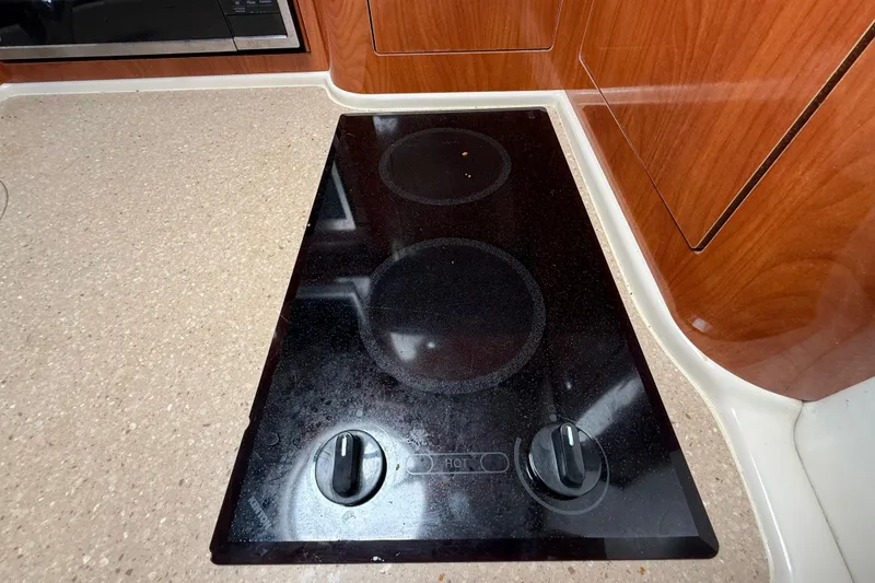 Slide: The Image of Stovetop in 2005 Four Winns 348 Vista boat kitchen, featuring sleek black design. - 60