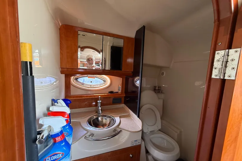 Slide: The Image of 2005 Four Winns 348 Vista yacht bathroom with sink, toilet, and cleaning supplies. - 65
