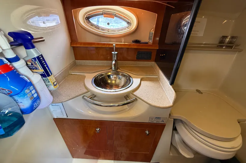 Slide: The Image of 2005 Four Winns 348 Vista boat bathroom with sink, toilet, and cleaning supplies. - 68