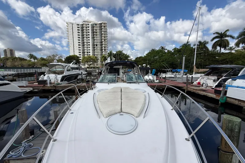 Slide: The Image of 2005 Four Winns 348 Vista yacht docked at marina, with cityscape and palm trees in background. - 88
