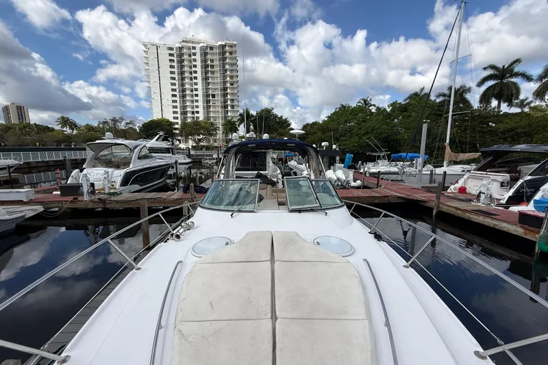 Slide: The Image of 2005 Four Winns 348 Vista yacht docked at marina, surrounded by other boats and palm trees. - 89
