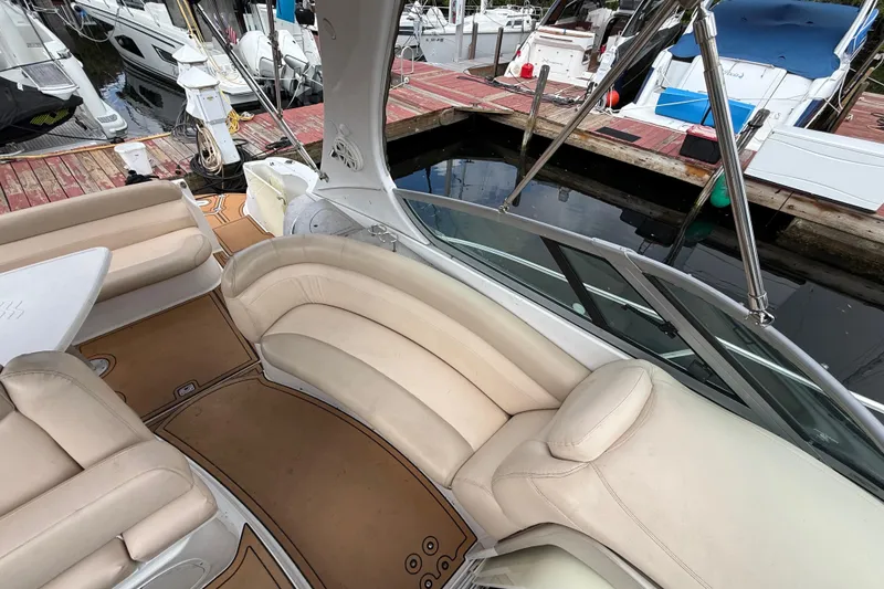Slide: The Image of 2005 Four Winns 348 Vista boat interior with beige seating at a marina dock. - 96