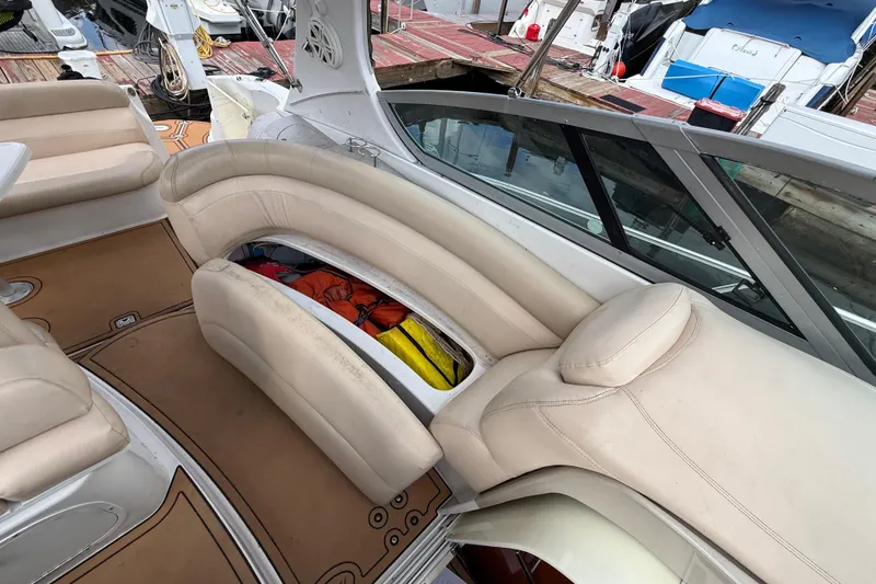 Slide: The Image of 2005 Four Winns 348 Vista boat interior with beige seating and storage compartment. - 97