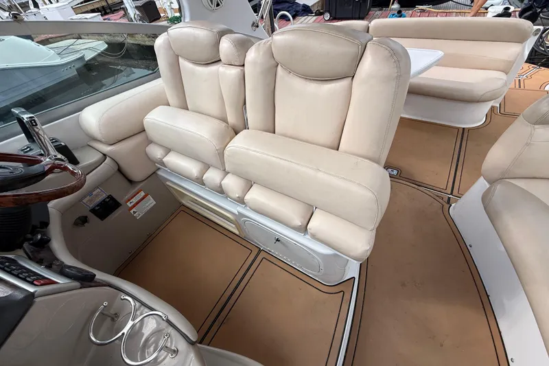 Slide: The Image of 2005 Four Winns 348 Vista boat interior with beige leather seating and steering area. - 98