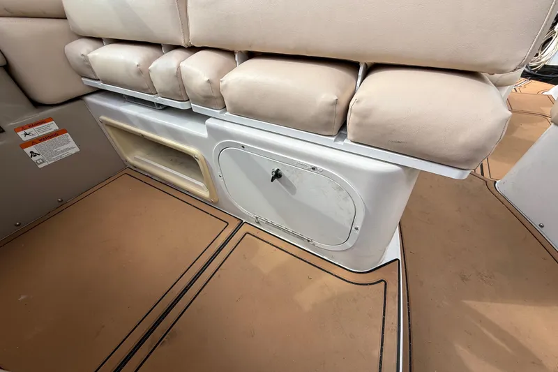 Slide: The Image of 2005 Four Winns 348 Vista boat interior with beige seating and storage compartments. - 99