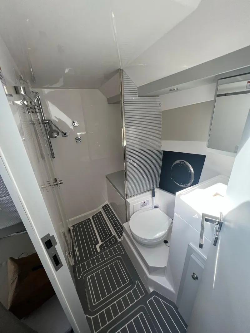 Slide: The Image of 2021 Evolve 400HT boat interior with white captain seats and striped towels, docked at marina. - 13